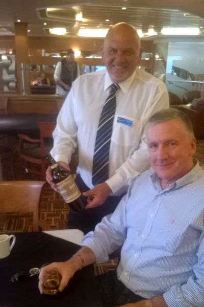 Eddie offers passengers a taste of St Magnus whisky by Highland Park on MV Hrossey
