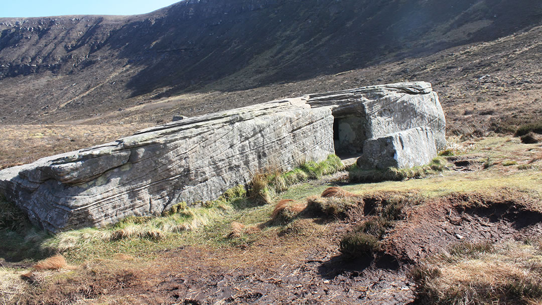 The Dwarfie Stane on Hoy in Orkney with the Dwarfie Hamars behind