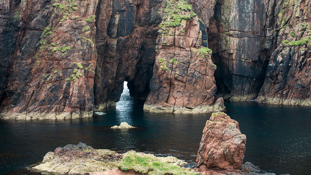 The red rock of Muckle Roe in Shetland