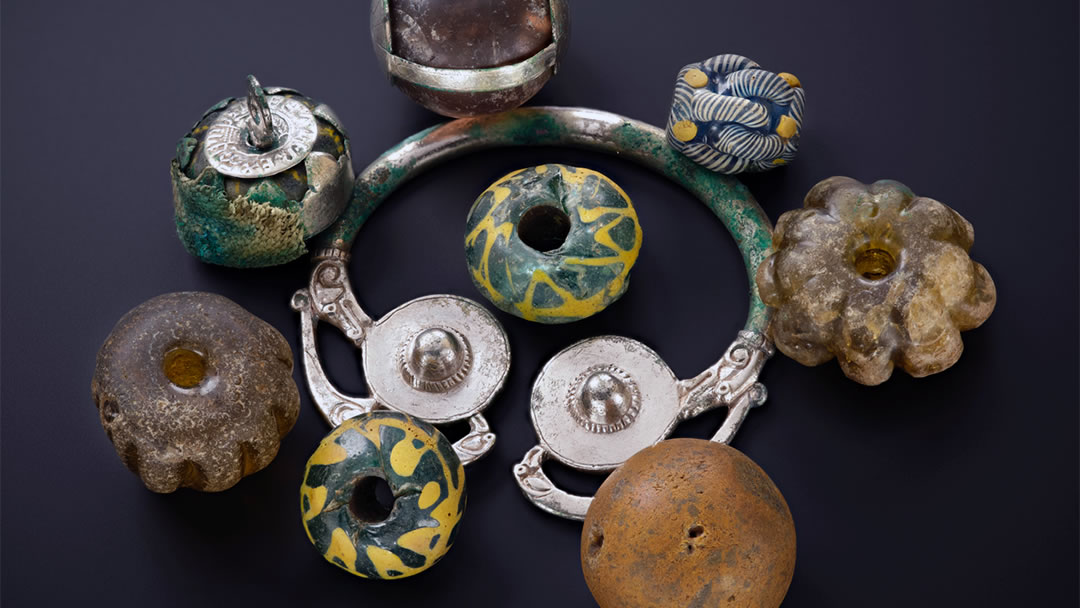 Beads, curios, and heirloom objects were bundled and strung together resting as a group on a silver brooch-hoop at the top of the lidded vessel in the Galloway Hoard
