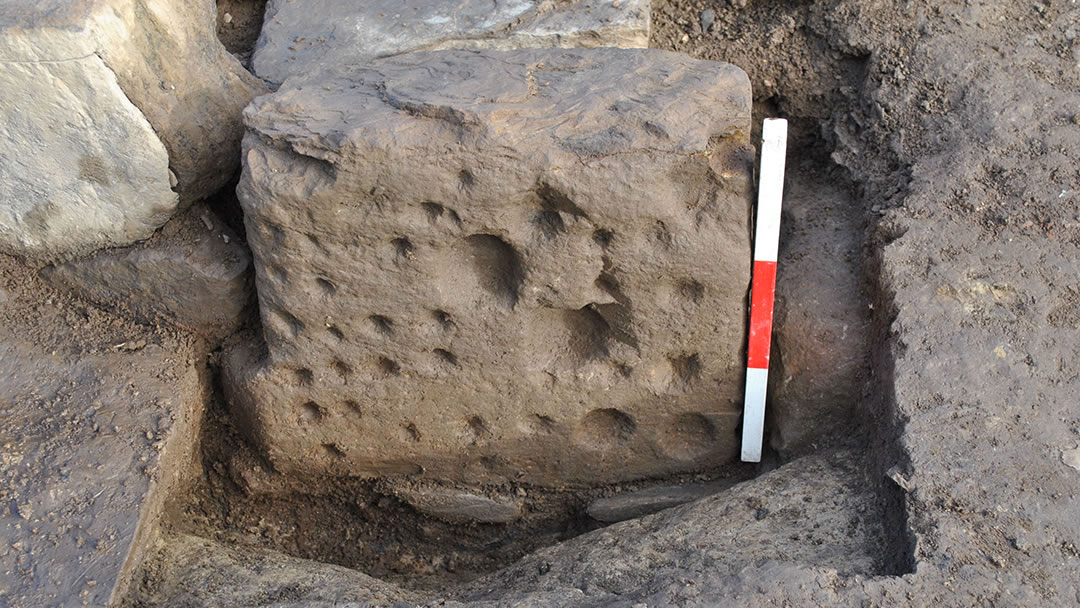 An elaborately decorated cup-marked stone forming part of the entrance into the largest building on the Ness