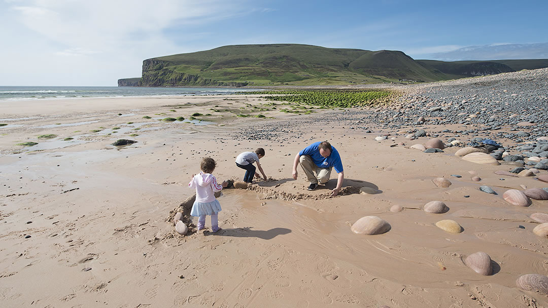 Playing in the sand at lovely Rackwick beach on the Orkney island of Hoy