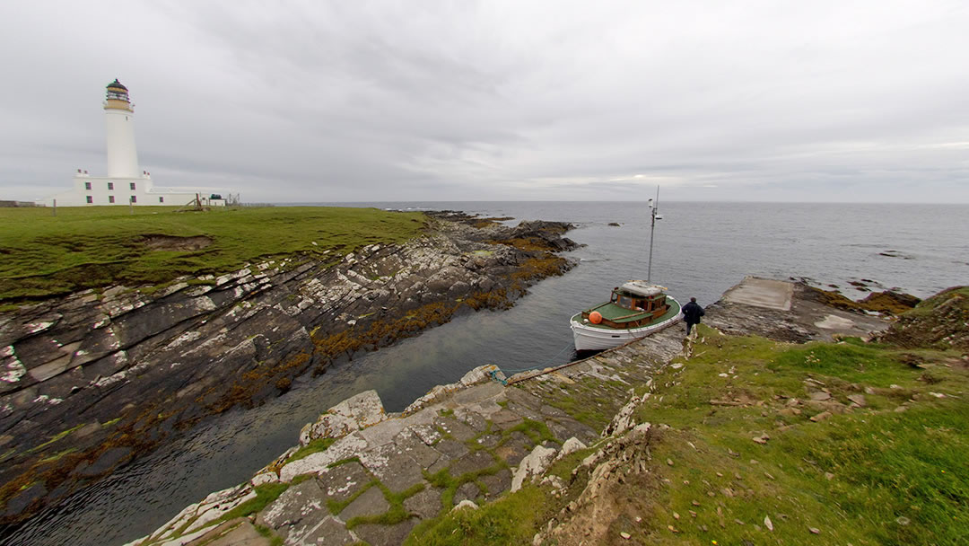 Auskerry lighthouse, with Shaalder docked at the pier