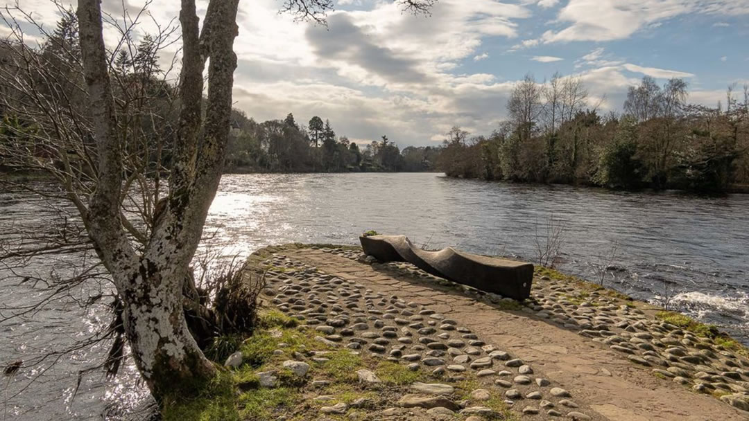 A wooden seat allows a visitor to view the River Ness as it cuts around one of the Ness Islands