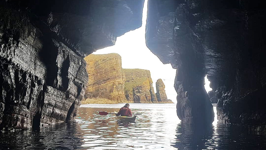 Exploring a sea cave in Orkney photo