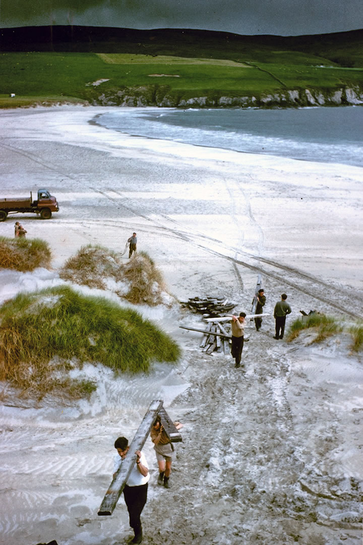 Carrying timbers up from the beach for the excavation site at St Ninian's Isle, in 1958