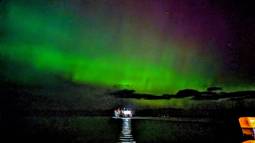 The MV Hjaltland departing Hatston Ferry Terminal below the spectacular Northern Lights