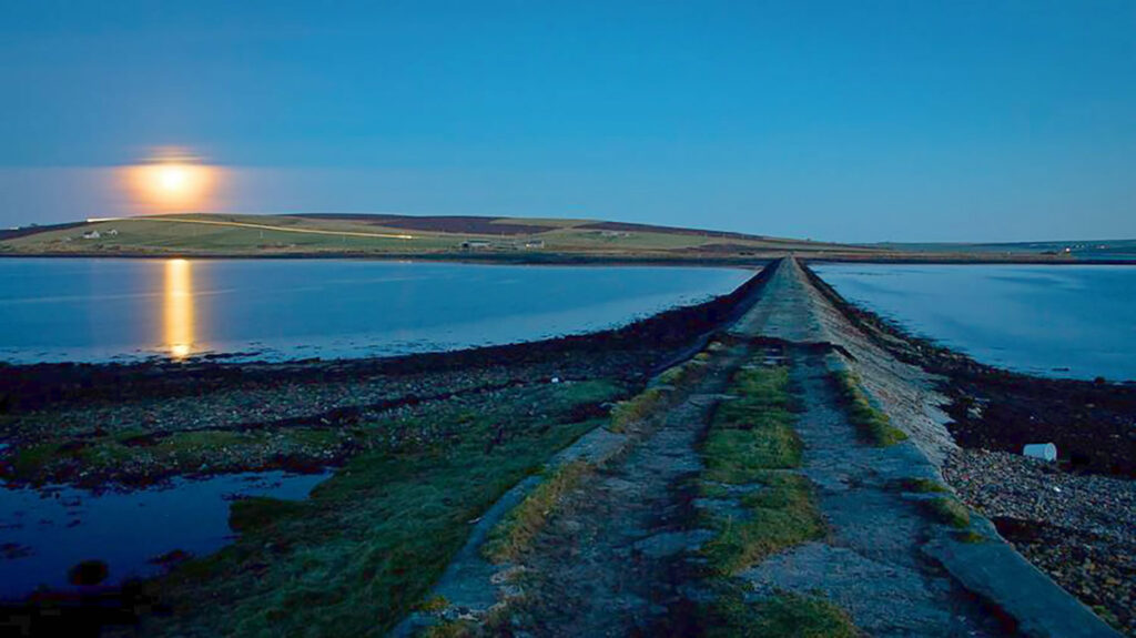 Rising moon over the causeway to Hunda in Orkney