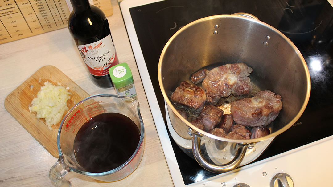 Sealing the oxtails in a hot pan