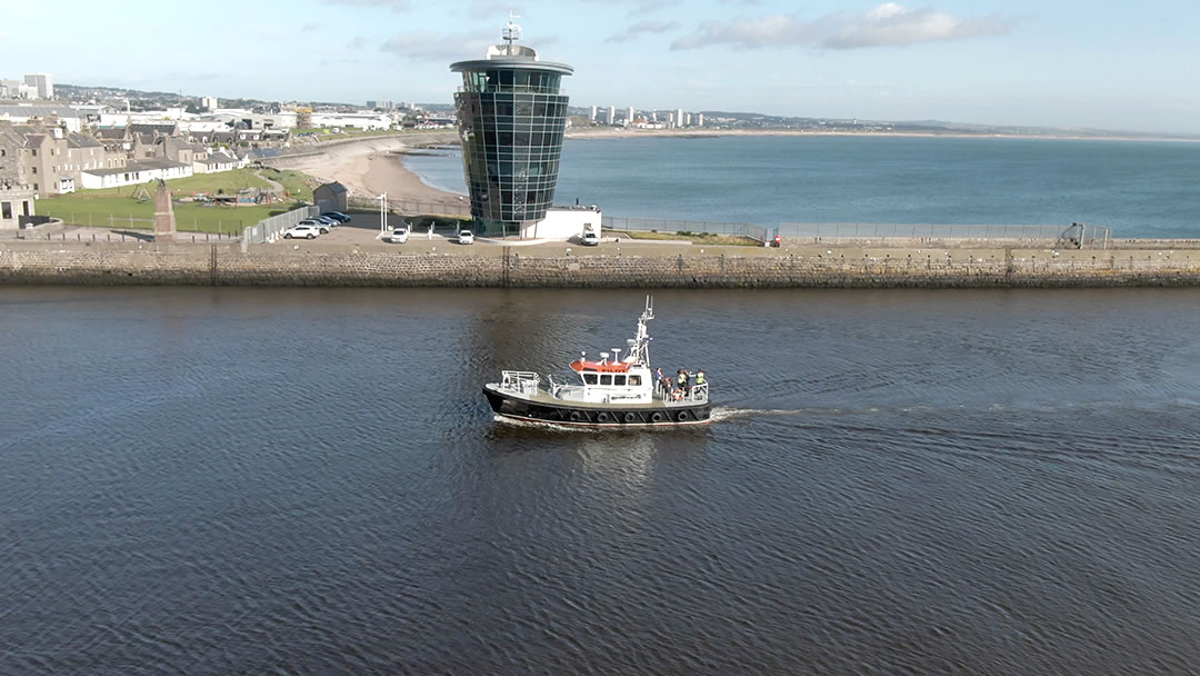A fishing vessel sails past the Aberdeen Marine Operations Centre