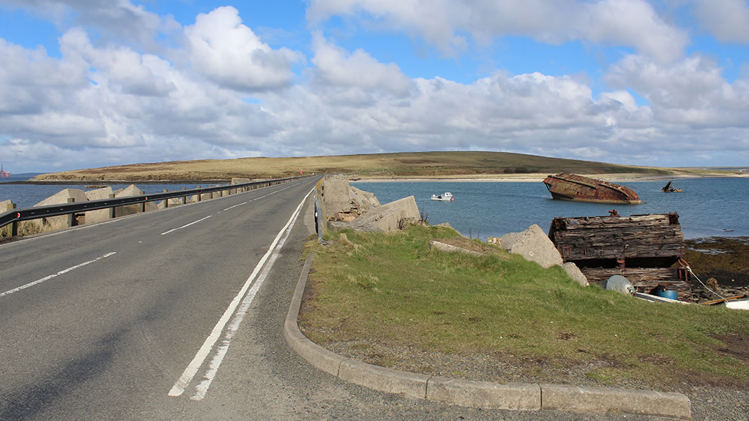 Looking at Glimps Holm from Burray, with the blockship Reginald on the right hand side