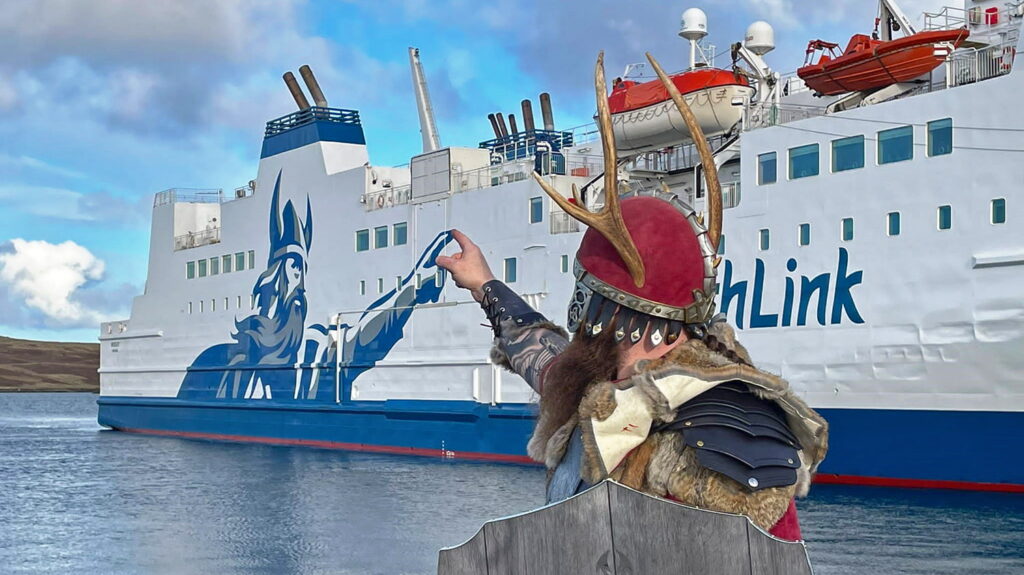 Member of the Delting Up Helly Aa Jarl squad making friends with NorthLink's own Viking, Magnus