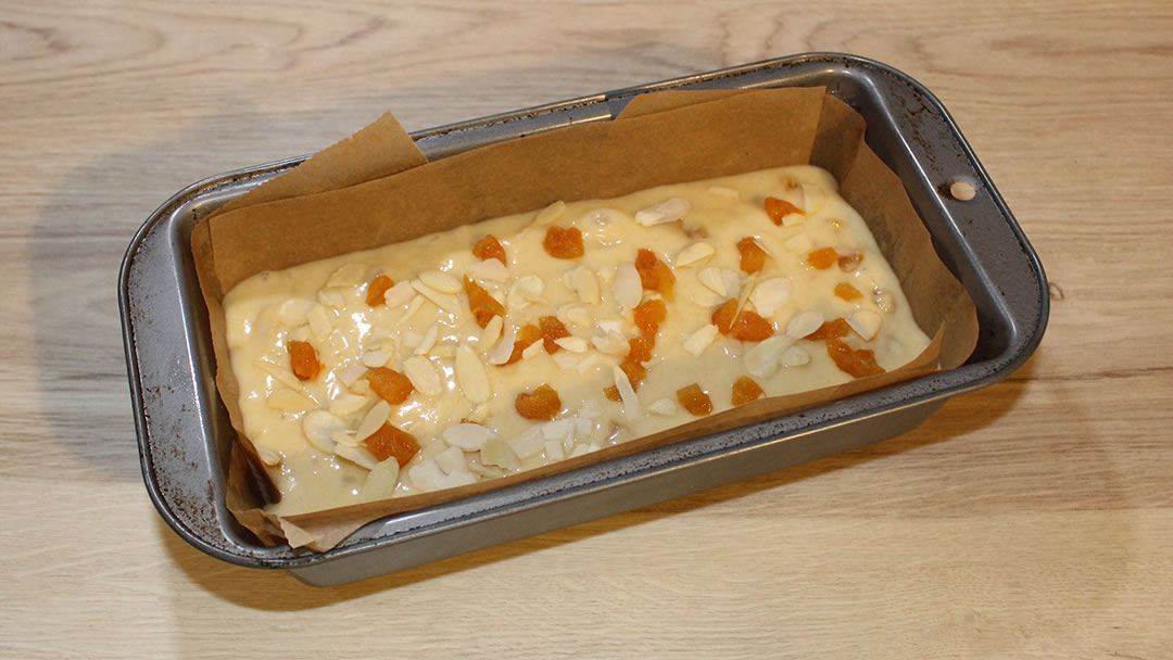 Place the mixture in a loaf tin and scatter the remaining apricots and flaked almonds on top