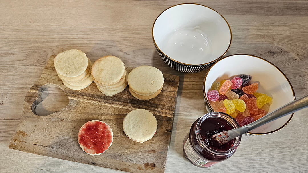 Sandwich pairs of the biscuits together with jam and top with a jelly sweet or a glacé cherry