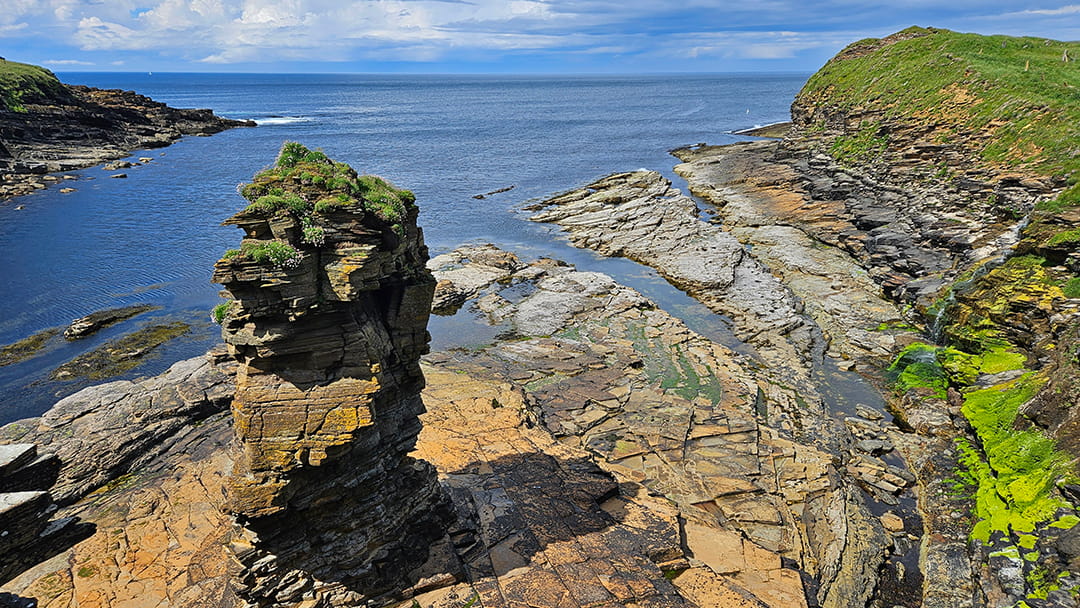 Dramatic rocky cliffs next to the Broch of Borwick