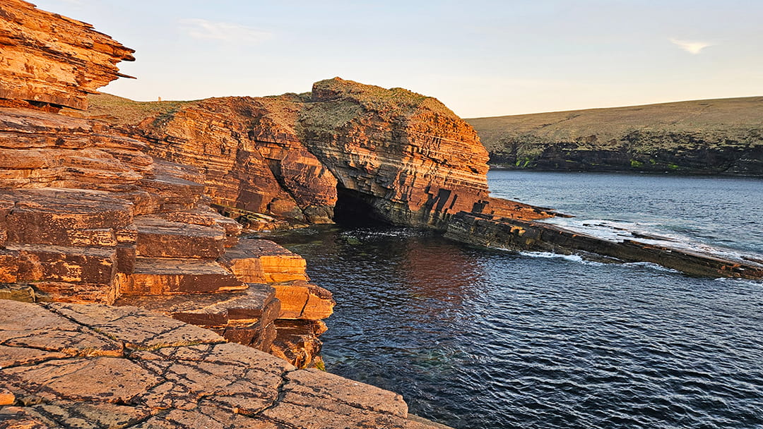 The deep Hell's Mouth sea cave in the cliffs below the Broch of Borwick
