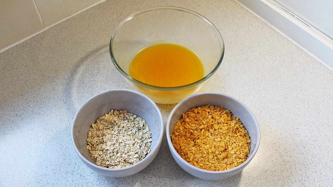 Add the crushed corn flakes and oats into the wet mixture